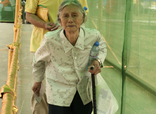 An aged woman waits to cast a vote on the demolishment and reconstruction of old buildings in Juixiaqiao Sub-district in Beijing, June 9, 2007. Local government and the real estate developer jointly organize the vote on Saturday to see if majority residents of over 5000 families accept the new compensation policy after failed attempts to reach an agreement through other ways. Both notary officials and supervisors are invited to monitor the vote that runs from 9 a.m. to 9 p.m. at six ballot booths. [Sun Yuqing/www.ttav89.com]