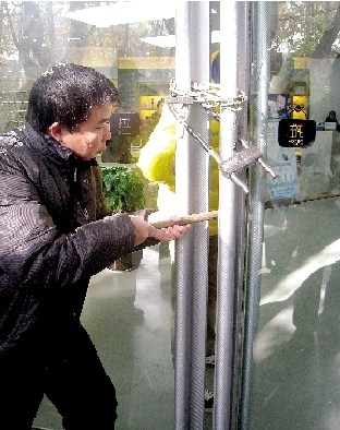 店員在玻璃門鎖三把鎖 小偷用長(zhǎng)棍挑走電腦(圖)