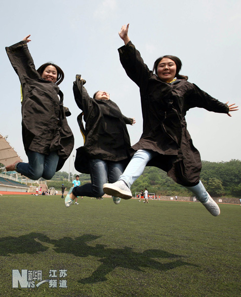 南京工業大學幾名畢業生在校園里拍攝趣味畢業照留念