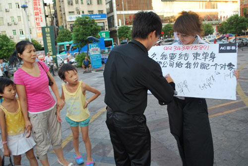 女職員當(dāng)街舉牌要公司分配對象 遭公司罰款(圖)