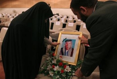Flowers and a portrait of Iraqi Shiite legislator Dhari Ali al-Fayadh are placed in an empty seat inside Iraq's National Assembly in Baghdad, Iraq Sunday, July 3, 2005. al-Fayadh was killed, along with his son and two body guards, by a car bomb on Tuesday, June 28 as they headed to a parliamentary session in the capital. (AP