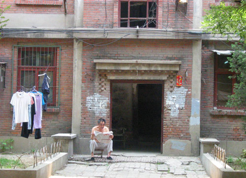A Chinese man reads newspaper in Juixiaqiao Sub-district in Beijing, June 9, 2007. Local government in Jiuxianqiao and the real estate developer jointly organize the vote on Saturday to see if majority residents of over 5000 families accept the new compensation policy after failed attempts to reach an agreement through other ways. Both notary officials and supervisors are invited to monitor the vote that runs from 9 a.m. to 9 p.m. at six ballot booths. [Sun Yuqing/www.ttav89.com]