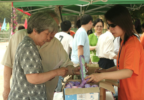Voters choose the umbrella as a souvenir after voting on demolishment and reconstruction of old buildings in Juixiaqiao Sub-district in Beijing, June 9, 2007. Local government and the real estate developer jointly organize the vote on Saturday to see if majority residents of over 5000 families accept the new compensation policy after failed attempts to reach an agreement through other ways. Both notary officials and supervisors are invited to monitor the vote that runs from 9 a.m. to 9 p.m. at six ballot booths. [Sun Yuqing/www.ttav89.com]