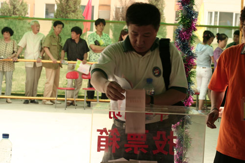 A voter casts his vote on demolishment and reconstruction of old buildings in Juixiaqiao Sub-district in Beijing, June 9, 2007. Local government and the real estate developer jointly organize the vote on Saturday to see if majority residents of over 5000 families accept the new compensation policy after failed attempts to reach an agreement through other ways. Both notary officials and supervisors are invited to monitor the vote that runs from 9 a.m. to 9 p.m. at six ballot booths. [Sun Yuqing/www.ttav89.com]