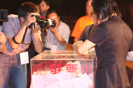 Photographers take the picture as two notary officials seal the balloting boxes after a voting on the housing demolition and compensation policy at Jiuxianqiao sub-district in Chaoyang District of Beijing, June 9, 2007. Some 3,711 families, about 57% of the 5,473 families, cast their votes on Saturday, with 2,451 votes for and 1,228 votes against the demolition and compensation plan. Thirty-two votes were invalid. [Sun Yuqing/www.ttav89.com]
