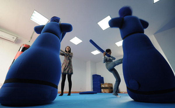 Two students beat dummies to vent their emotion on the opening day of an innovative service centre at Anhui University, Hefei city, capital of in East China’s Anhui province, May 24, 2011. New ways for students to vent pressure