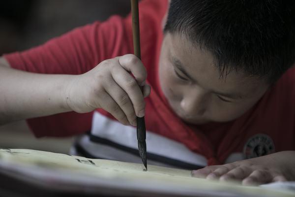 認(rèn)真撰寫(xiě)毛筆字的塘市小學(xué)學(xué)生