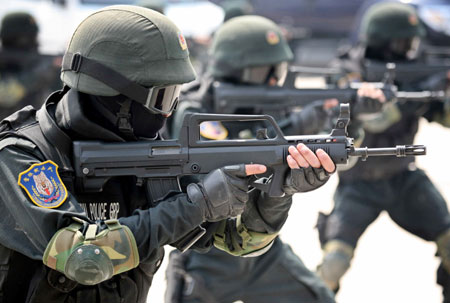 Masked members of a Chinese police SWAT team perform their skills at a ceremony to launch their Olympic security training programme in Beijing April 27, 2006. Beijing's 40,000 police officers, and any more recruited before the Olympics, will take part in the training with the majority having language training to deal with the more than two million visitors expected before and during the games.