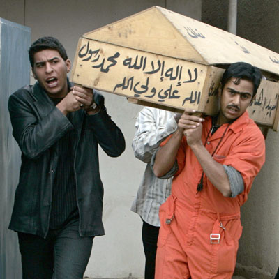 Residents carry the coffin, inscribed with Koranic verses, of a gunshot victim from Yarmouk hospital morgue in Baghdad, November 7, 2006. A total of 10 bodies were found with gunshot wounds during the last 24 hours in different districts of Baghdad, an Interior Ministry source said. 