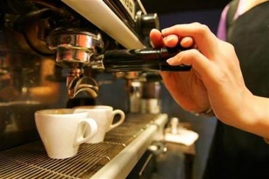 A worker pumps coffee at a coffee shop in Taipei August 3, 2006. In a small study of female college students, researchers found that a caffeine supplement seemed to lessen the muscle pain that crops up a day after a challenging workout. 